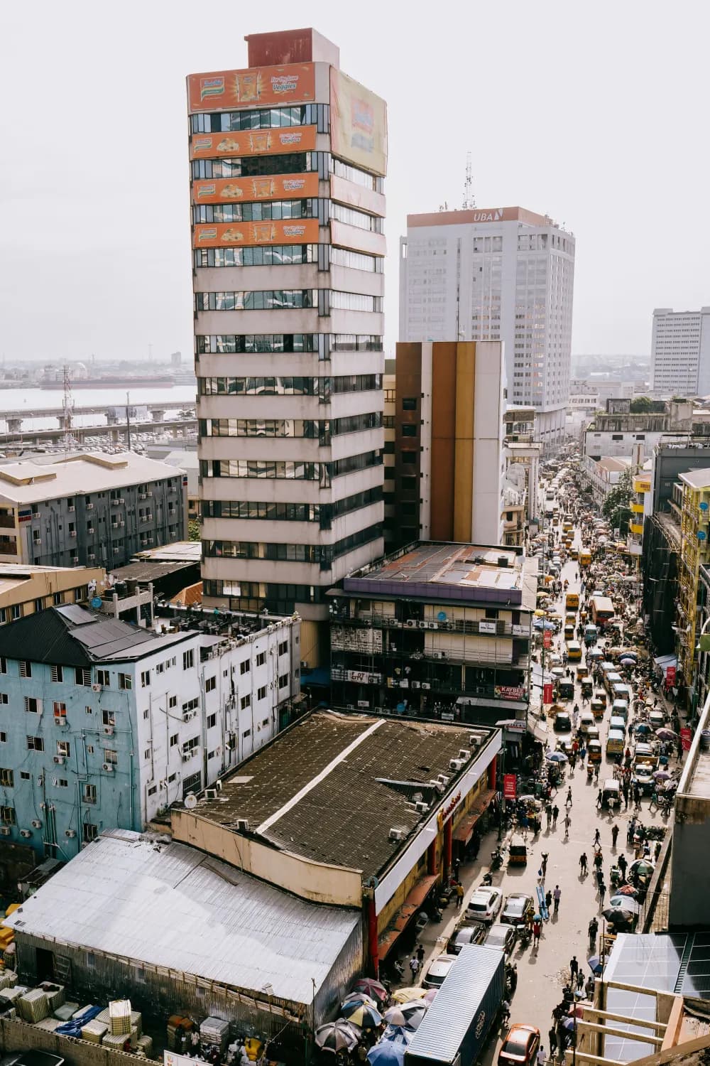 A busy city street seen from above, lined with shops and traffic
