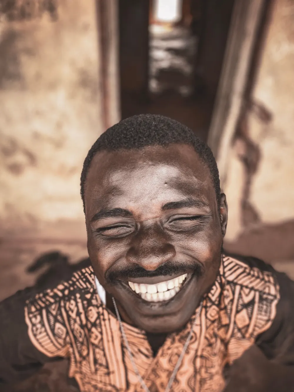 A man laughing with his eyes closed